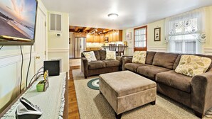 A living room with a large flat-screen TV, a sofa set, and a dining area with a kitchen in the background. - Sea Horse Cottage-5 Bedrooms, 3 Full Baths, 2 Half Baths, Sleeps 14 (West Cape May)