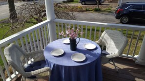 Un espace extérieur abrité, aménagé avec une table, des chaises et un pot de fleurs.
