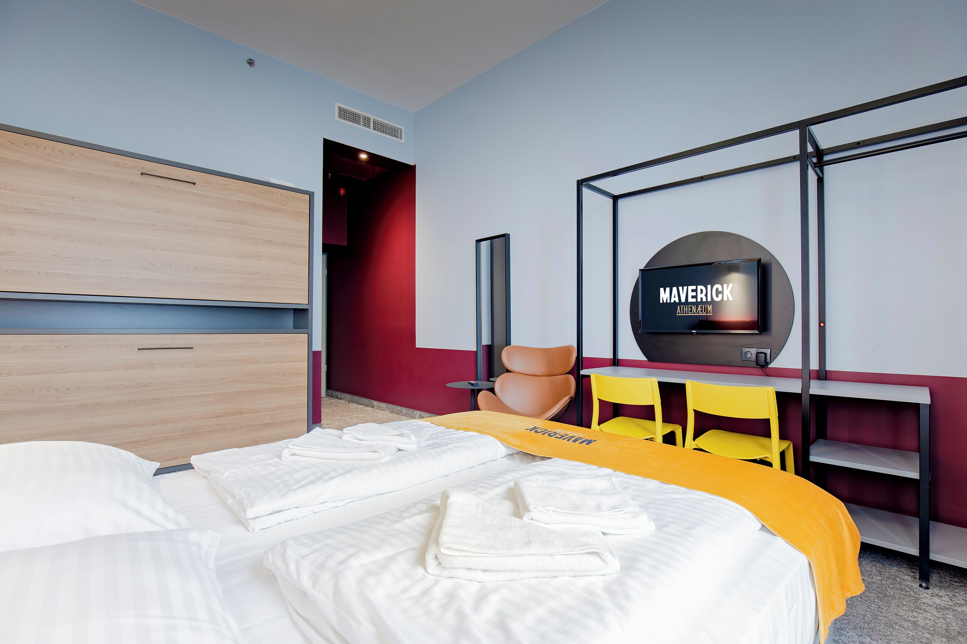 Una habitación de hotel con cama, televisión, escritorio y silla.