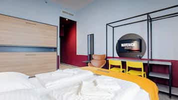 Una habitación de hotel con cama, televisión, escritorio y silla.