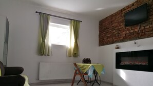 A room with a brick wall, a fireplace, a table with a tablecloth, and a chair. - Courage place is sunny (Cluj-Napoca)