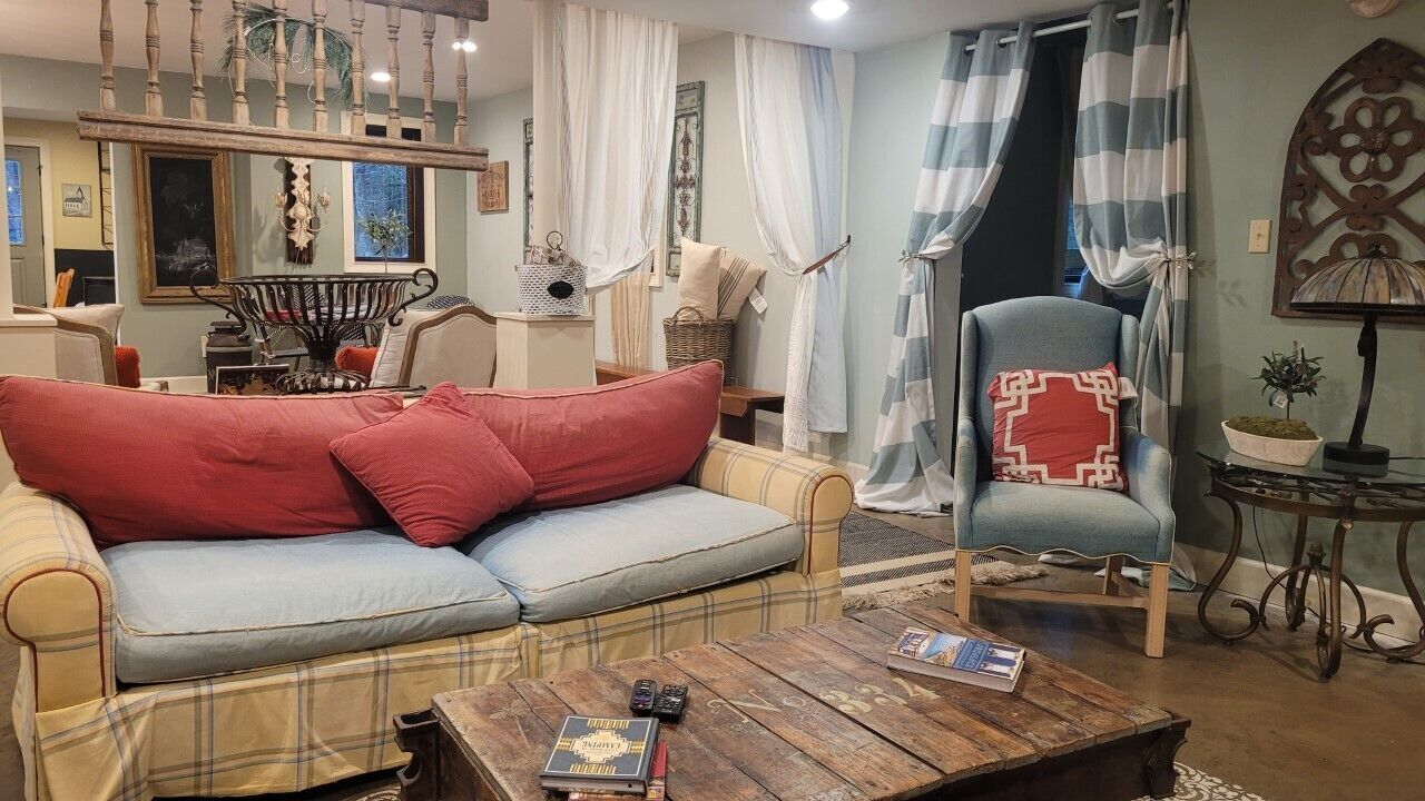 A cozy living room with a plaid sofa, a wooden coffee table, and a blue armchair.