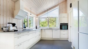 A modern kitchen with white cabinetry, a built-in oven, and a coffee machine. - Amazing home in Rømø with WiFi (Rømø)