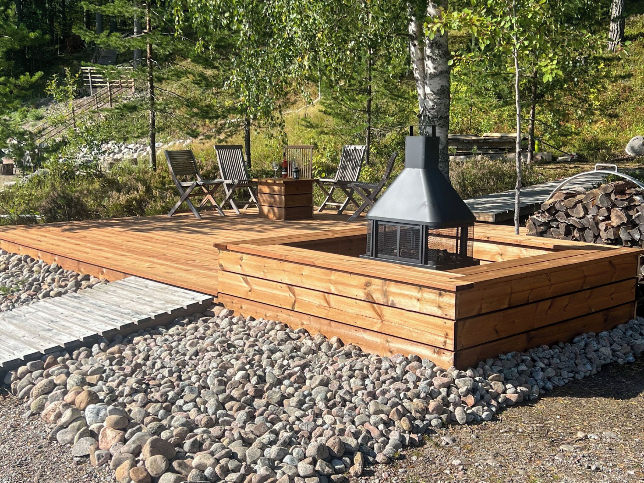 Eine Holzterrasse mit integriertem Kamin und Sitzbereich.