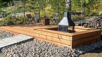 Eine Holzterrasse mit integriertem Kamin und Sitzbereich.
