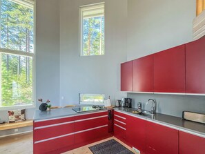 Una cocina moderna con armarios rojos, una estufa a gas y un lavamanos.