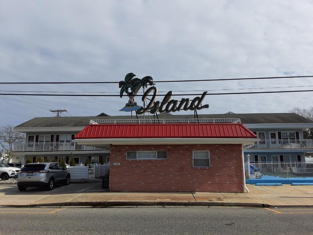A building with a red roof and a sign that reads "Island."
