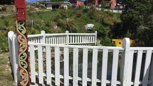 Un recinto in legno bianco con un palo decorativo raffigurante un volto intagliato.