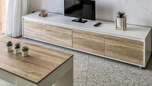 Una sala de estar moderna con una consola de madera y blanca, un televisor de pantalla plana y pequeñas macetas.