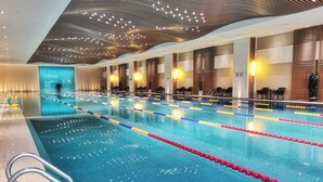 Une piscine dotée de plusieurs couloirs, d’une bouée de sauvetage et d’un design moderne au niveau du plafond.