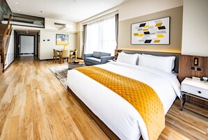 Una camera d'albergo moderna con un letto grande, una scrivania, una sedia e un divano.