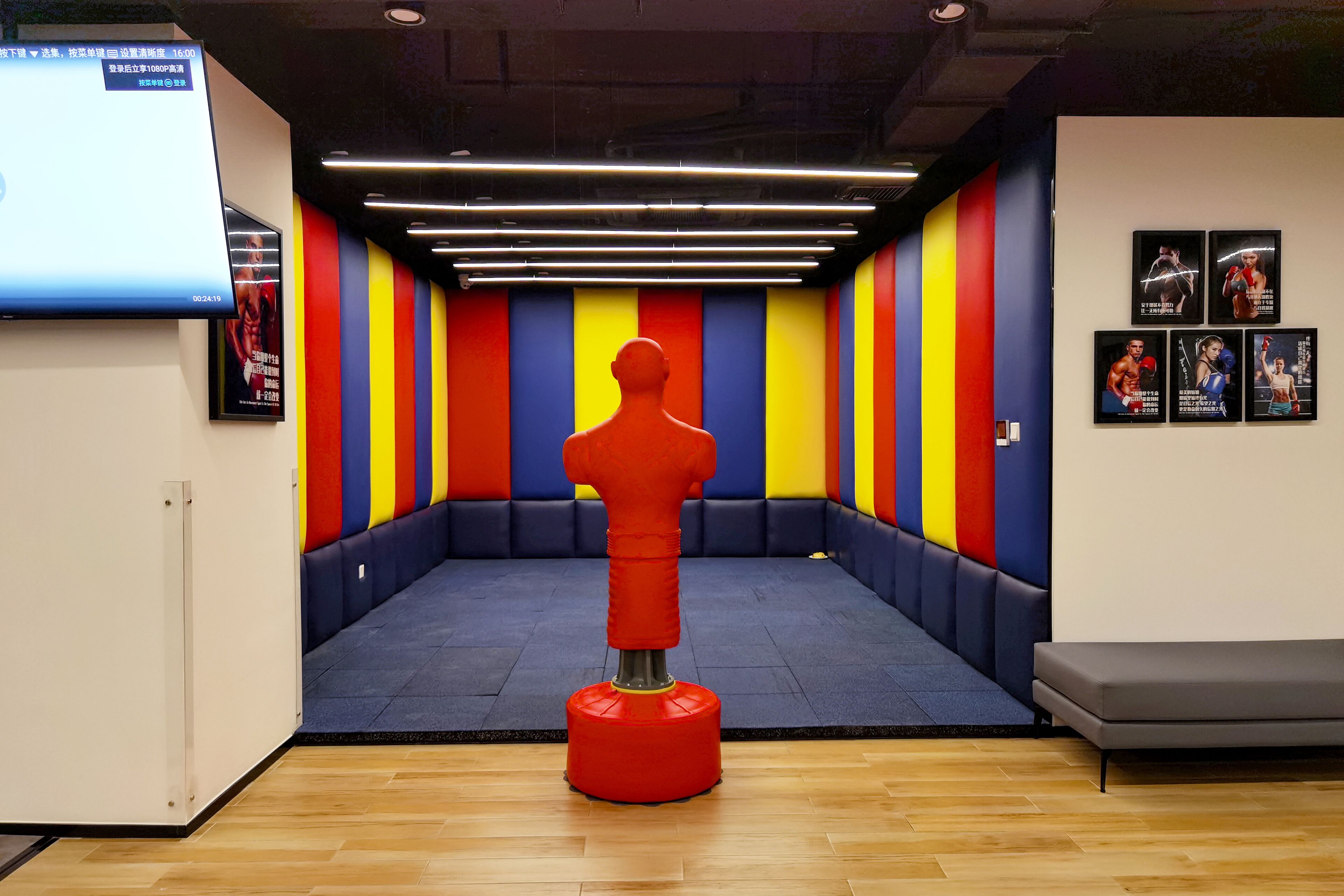 A room with a colorful wall, a punching dummy, and posters on the wall.