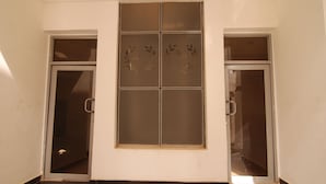 A hallway with a large decorative window and two doors. - Fisher Suites and Apartments (Abuja)