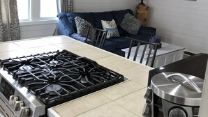 Une cuisine équipée d’une cuisinière à gaz, d’une machine à café et d’un meuble avec un miroir.