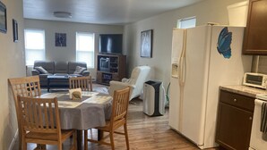 A compact living space with a dining area, kitchen, and a living room.