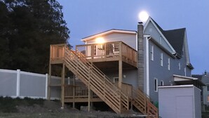 A two-story house with a wooden staircase leading to a balcony.