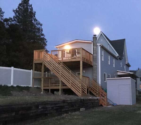 A two-story house with a wooden staircase leading to a balcony.