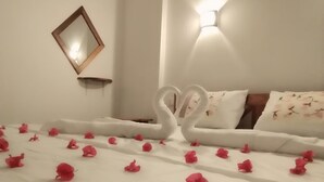A neatly made bed with white bedding and pink rose petals arranged in a heart shape. - The Grand Leisure Villa (Udawalawa)