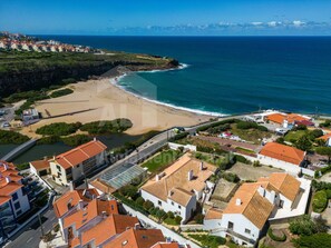Experience the charm of a Mediterranean coastal town with its picturesque beach and scenic bridge connecting the area.