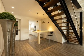 Stylish living area with a dining space, wooden staircase, and natural accents.