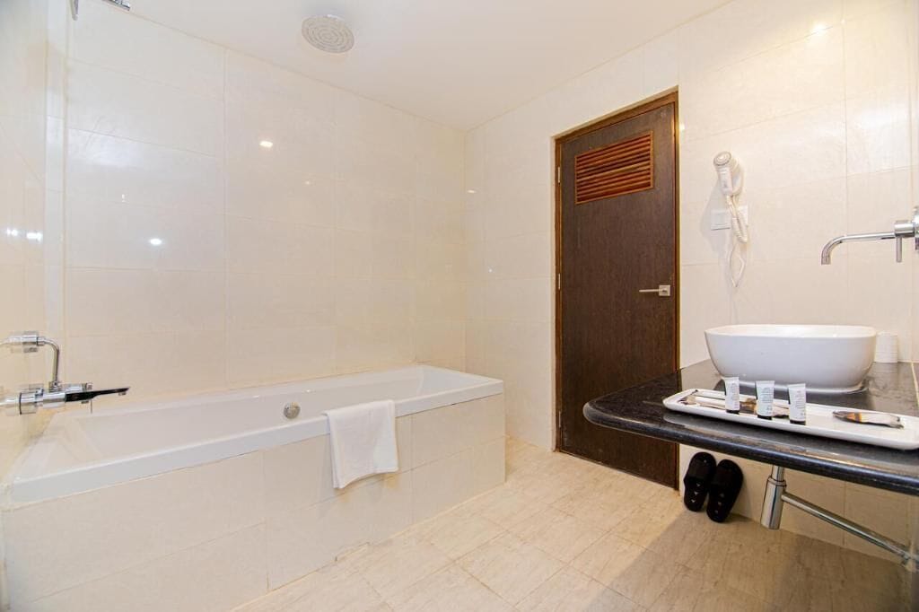 Un baño moderno con bañera, lavamanos y zona de ducha.