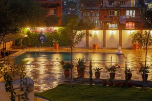 A rooftop pool area with potted plants and a mural. - Hotel Bhadgaon (Bhaktapur)
