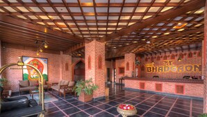 A hotel lobby with a check-in counter, seating area, and a reception desk. - Hotel Bhadgaon (Bhaktapur)