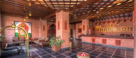 Un vestíbulo de hotel con mostrador de recepción, zona de estar y escritorio.