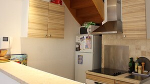 Une cuisine avec des meubles de rangement en bois, un réfrigérateur en acier inoxydable, un four à micro-ondes et une cuisinière.