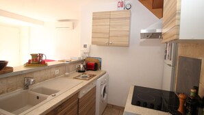 Une cuisine moderne équipée d’un évier, d’une cuisinière et d’un lave-linge.
