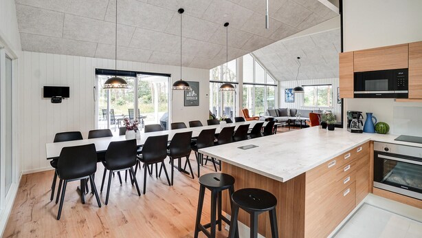 A modern kitchen with a large island, wooden cabinets, and stainless steel appliances. - Pet friendly home in Nexø with kitchen (Nexø)