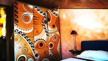 Una stanza con un letto, una lampada e un muro decorato con un murale colorato.