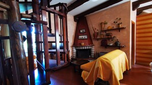 A cozy room with a wooden chair, a fireplace, and a table covered with a yellow cloth. - Chalet "Mon Amour" - Relax & Sky (Campo di Giove)