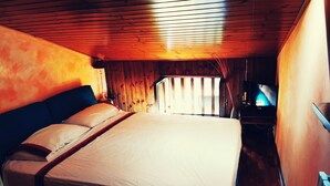 A wooden cabin bedroom with a bed, a television, and a window. - Chalet "Mon Amour" - Relax & Sky (Campo di Giove)