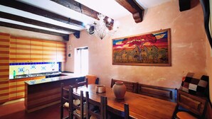 A rustic kitchen with wooden beams, a tiled backsplash, and a painting of zebras. - Chalet "Mon Amour" - Relax & Sky (Campo di Giove)