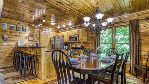 L’intérieur d’une cabane en bois comprend un coin repas, une cuisine et un bar.