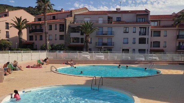 A swimming pool area with two pools, surrounded by apartment buildings with balconies. - Cozy studio in Collioure with sunny terrace (Collioure)