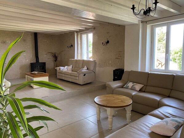 A living room with a sofa, a wooden coffee table, a TV, and a plant. - Beautiful Secluded All Ensuite Property with Private Heated Pool – Sleeps 15 (Fonroque)