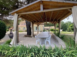 A covered outdoor dining area with a pergola, a table set for four, and a hanging chair. - Beautiful Secluded All Ensuite Property with Private Heated Pool – Sleeps 15 (Fonroque)