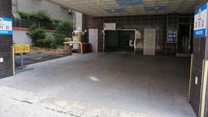 A hotel entrance with a tiled floor, a signboard, and a no-smoking sign. - Hawaii Hotel (Tongyeong)