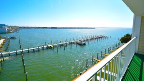 A balcony with a view of a marina, docked boats, and a clear blue sky. - Thunder Island 80B-Baywater 39th St, Free WiFi, Pool, Elev, W/D, AC (Ocean City)