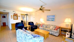 A living room with a ceiling fan, a sofa, a chair, a coffee table, and a lamp. - Thunder Island 80B-Baywater 39th St, Free WiFi, Pool, Elev, W/D, AC (Ocean City)