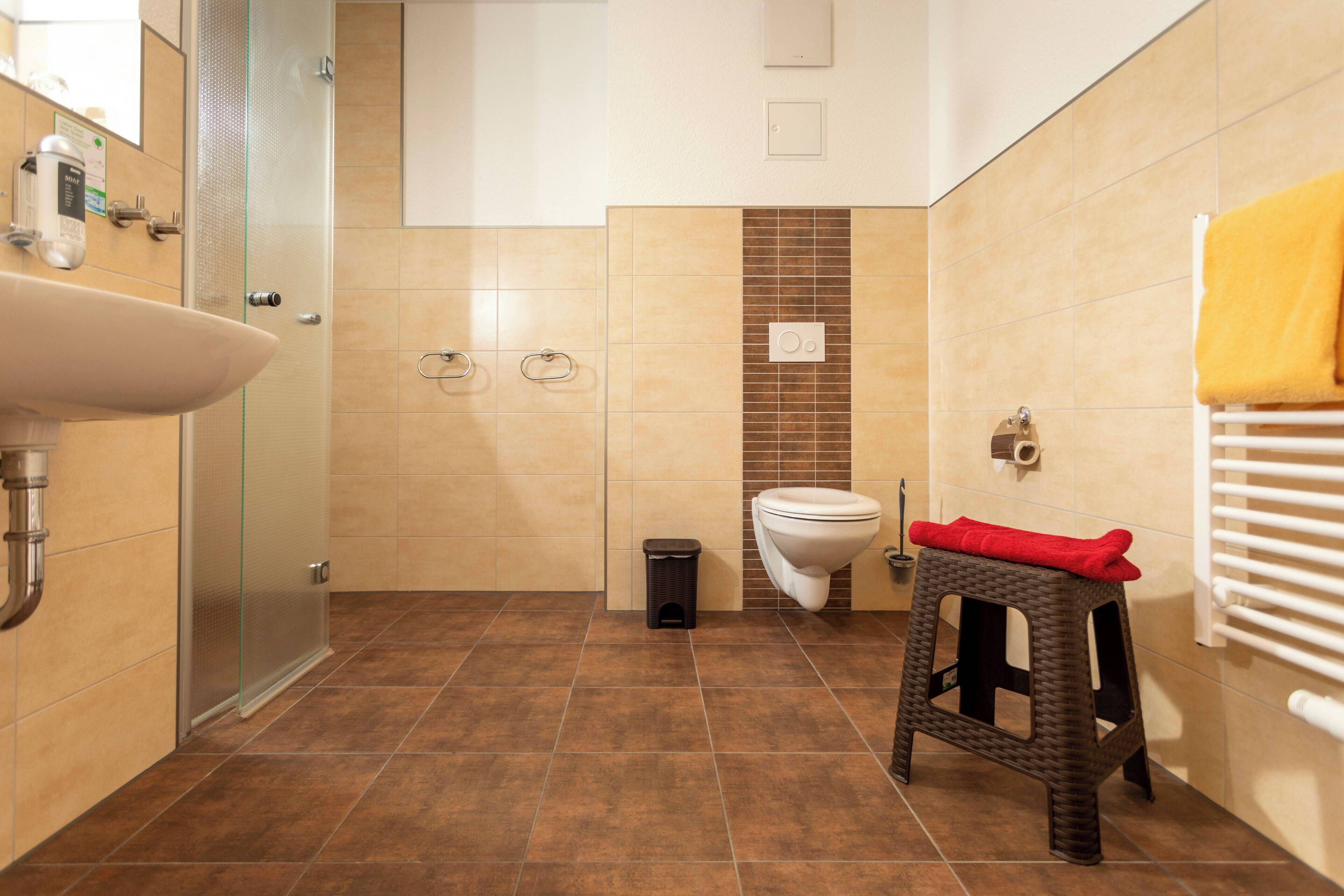 Un baño con lavamanos, inodoro y ducha.