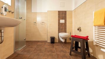 Un baño con lavamanos, inodoro y ducha.