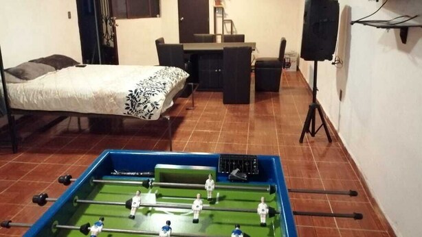 A room with a bed, a desk, a chair, a foosball table, and a TV. - El Teotihuacano is 1.5 km away. From the archaeological zone (San Juan Teotihuacan)