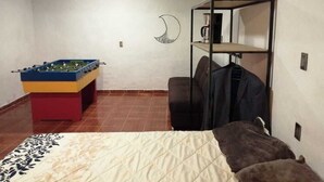 A room with a bed, a foosball table, a chair, and a shelf with a coffee machine. - El Teotihuacano is 1.5 km away. From the archaeological zone (San Juan Teotihuacan)