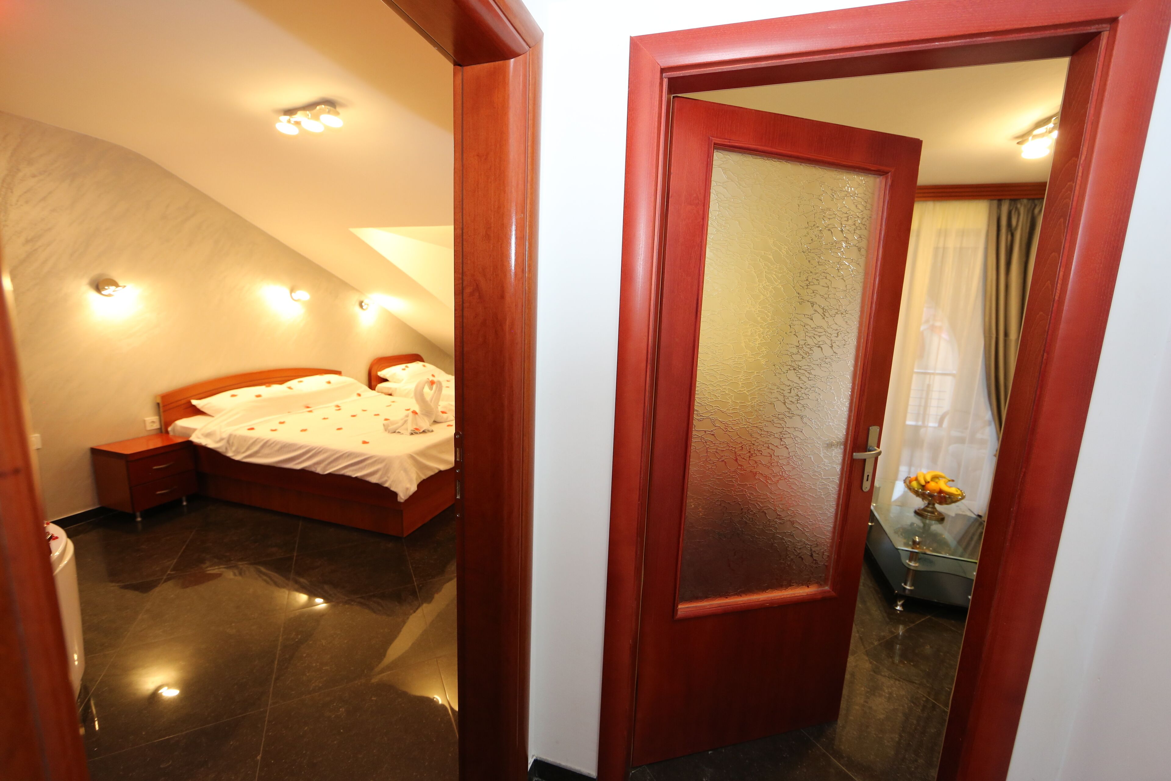 Un dormitorio con cama, mesita de noche y una puerta que da a otra habitación.