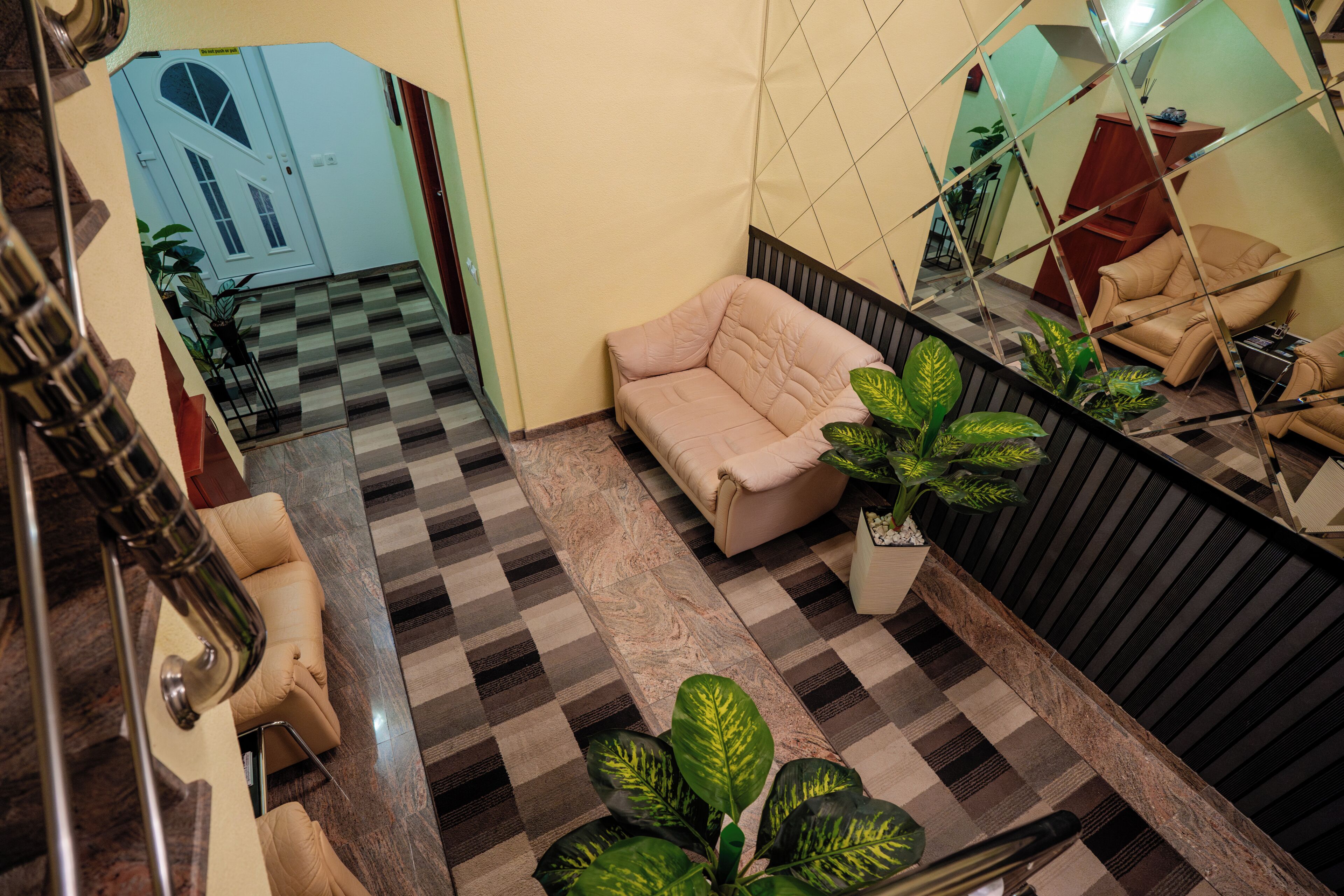 A checkered floor, a sofa, and a mirror in a room.