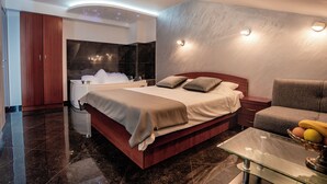 Quarto moderno com cama, mesa de cabeceira e mesa de centro de vidro.