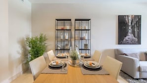 A dining area with a wooden table set for four, flanked by two black shelving units with glass doors. - Hoyo19 11 | Premier Luxury Holiday Resort (Málaga)